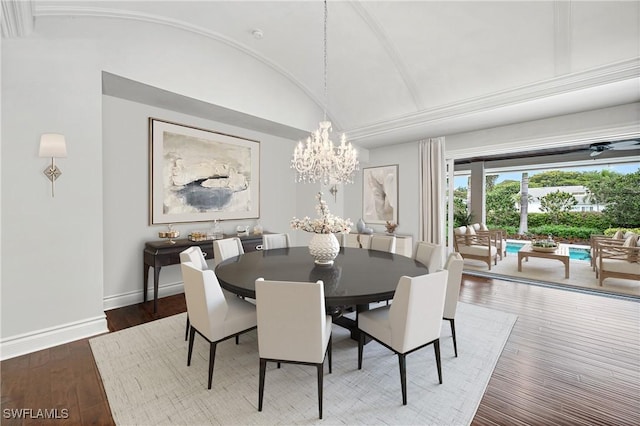 dining area featuring a chandelier, wood-type flooring, and vaulted ceiling