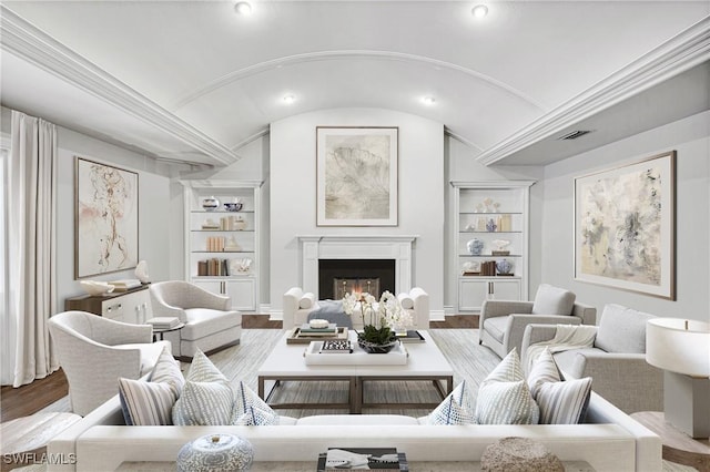 living room with hardwood / wood-style flooring, lofted ceiling, and built in features