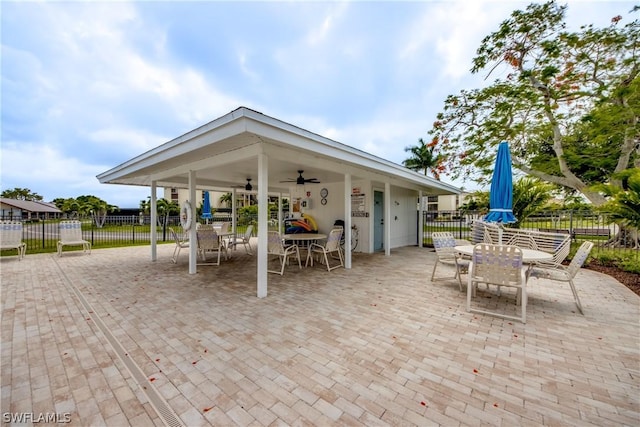 view of patio featuring outdoor dining space, fence, and a ceiling fan