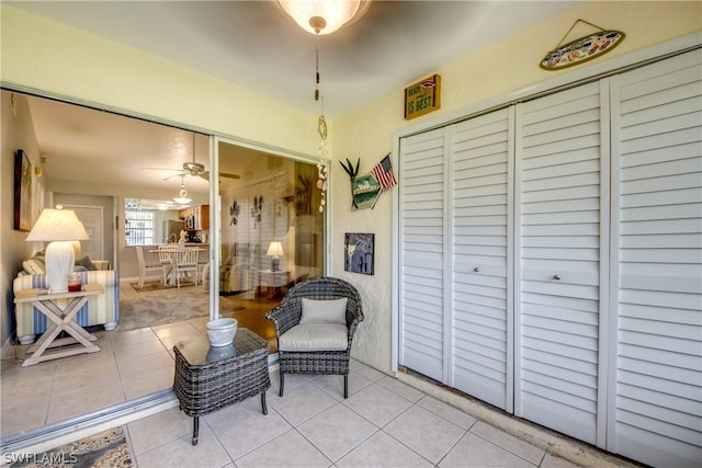 sitting room featuring ceiling fan and light tile patterned floors