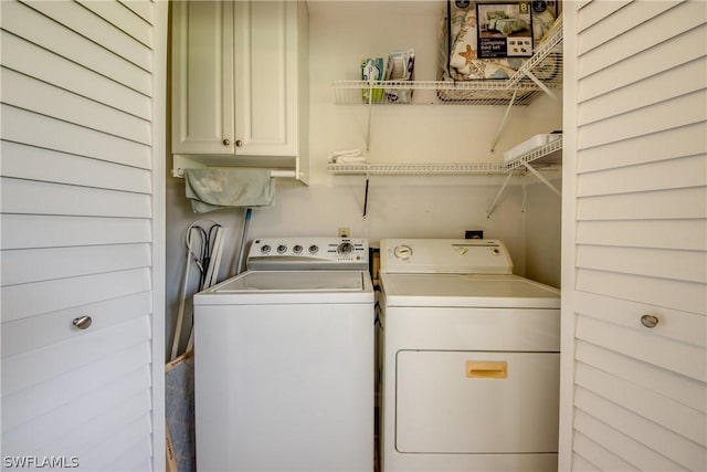 washroom with cabinet space and washer and clothes dryer