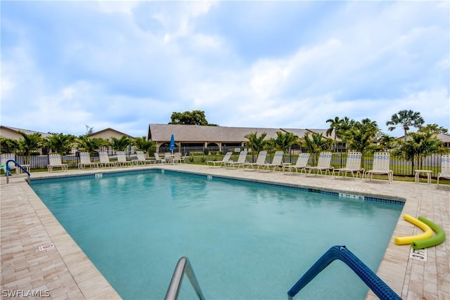 community pool featuring a patio area and fence