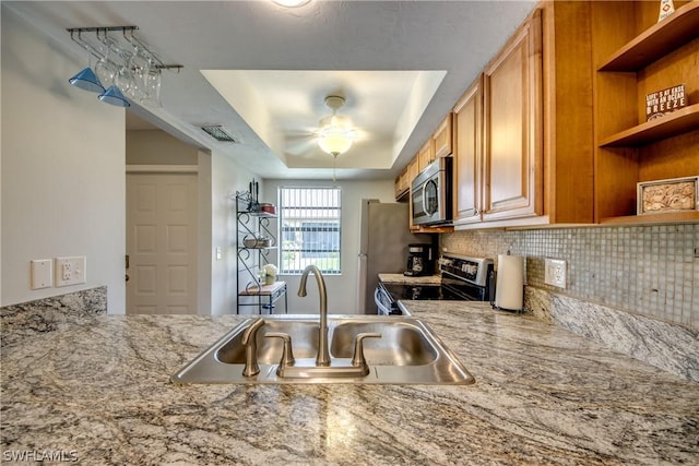 kitchen featuring stainless steel appliances, a sink, visible vents, open shelves, and a tray ceiling