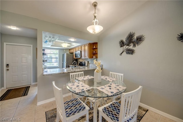 dining room featuring baseboards and light tile patterned floors