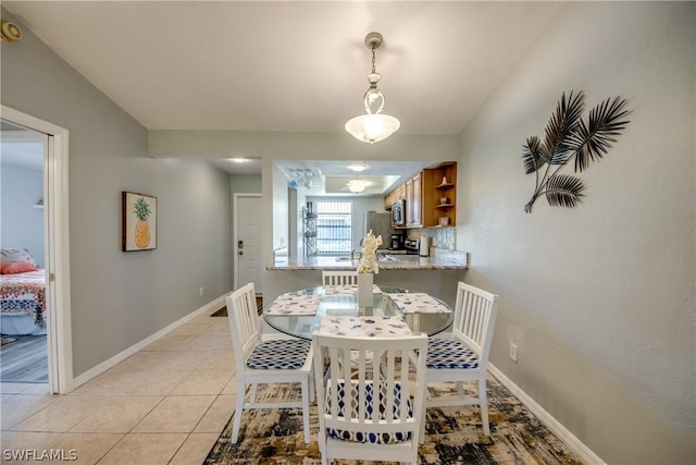 dining area featuring light tile patterned floors and baseboards