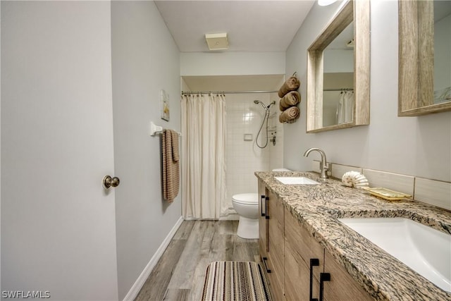 full bath featuring wood finished floors, a sink, toilet, and baseboards