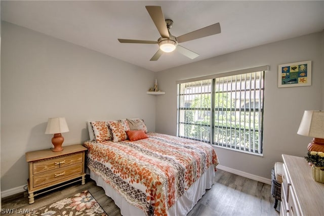 bedroom featuring light wood finished floors, ceiling fan, and baseboards