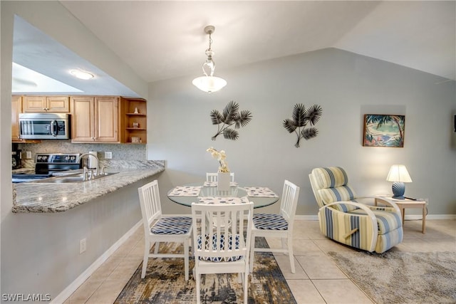 dining area featuring light tile patterned flooring, vaulted ceiling, and baseboards