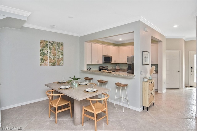 tiled dining space featuring crown molding