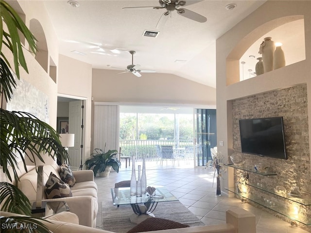 tiled living room featuring ceiling fan and vaulted ceiling