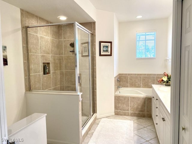 bathroom with tile patterned flooring, vanity, and shower with separate bathtub