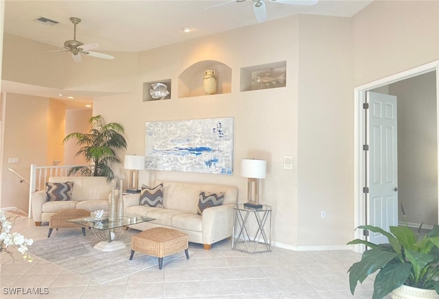 tiled living room featuring ceiling fan and a high ceiling