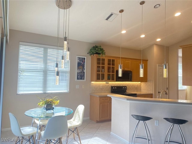 kitchen with decorative backsplash, sink, black appliances, light tile patterned floors, and pendant lighting