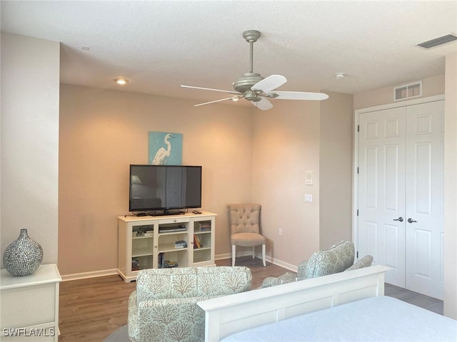 bedroom with dark hardwood / wood-style flooring, a closet, and ceiling fan