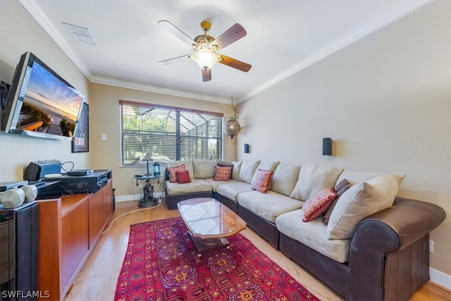 living room with ceiling fan, ornamental molding, and light hardwood / wood-style flooring