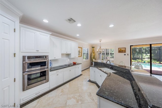 kitchen featuring light tile flooring, hanging light fixtures, sink, white cabinets, and double oven