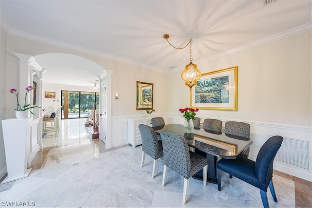 tiled dining area with a notable chandelier, ornate columns, and crown molding