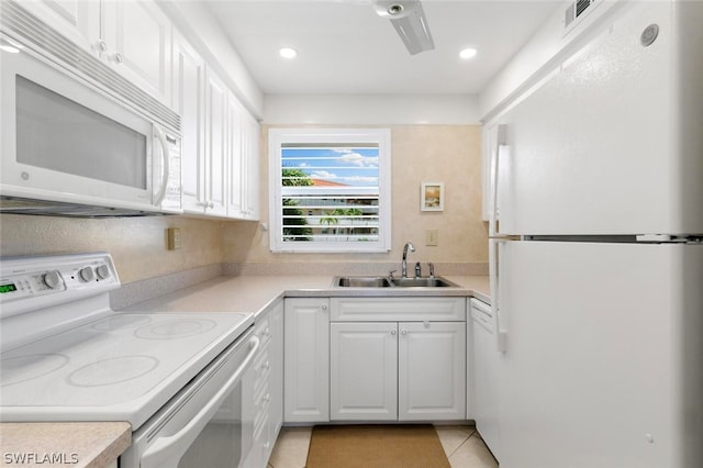 kitchen featuring white appliances, sink, white cabinets, and light tile flooring