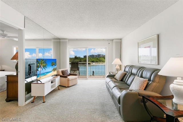 living room with ceiling fan, a textured ceiling, and carpet floors