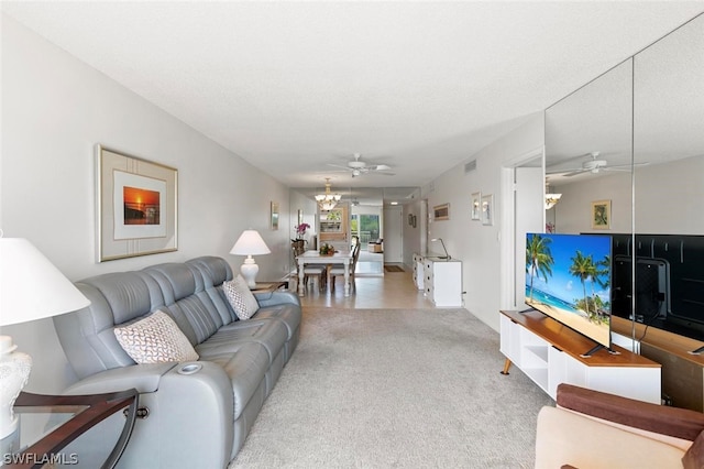 living room with a textured ceiling and ceiling fan with notable chandelier