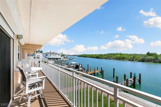 balcony with a boat dock and a water view