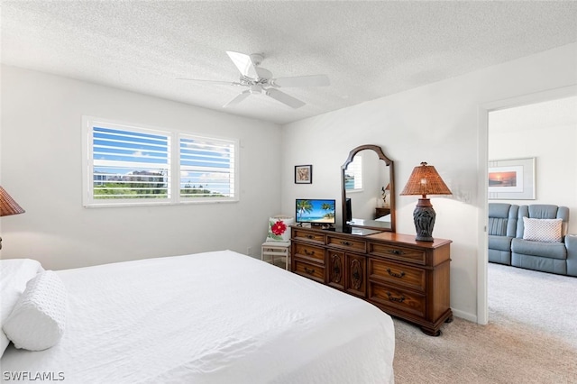 carpeted bedroom with ceiling fan and a textured ceiling