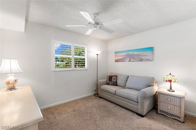 living room with carpet, ceiling fan, and a textured ceiling