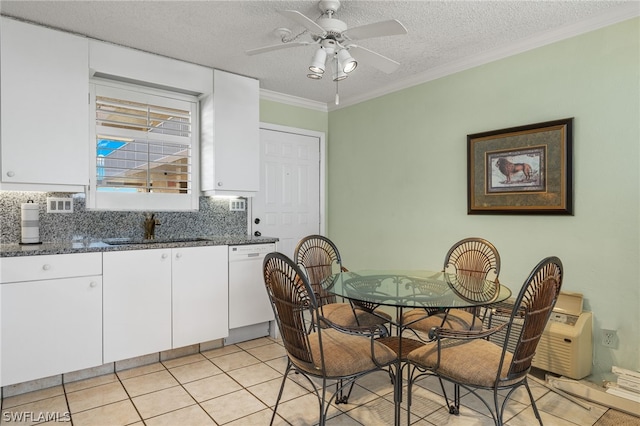 tiled dining space featuring crown molding, sink, ceiling fan, and a textured ceiling