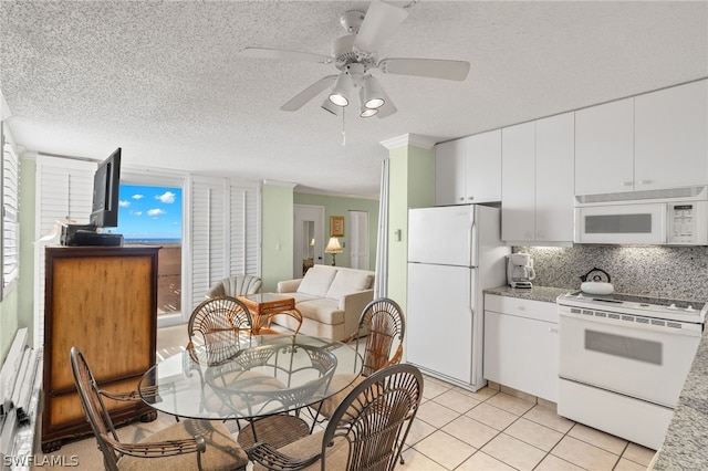 kitchen featuring light tile flooring, backsplash, ceiling fan, white cabinets, and white appliances