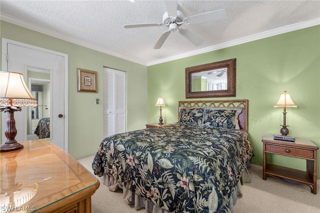 carpeted bedroom with ceiling fan, a closet, a textured ceiling, and ornamental molding