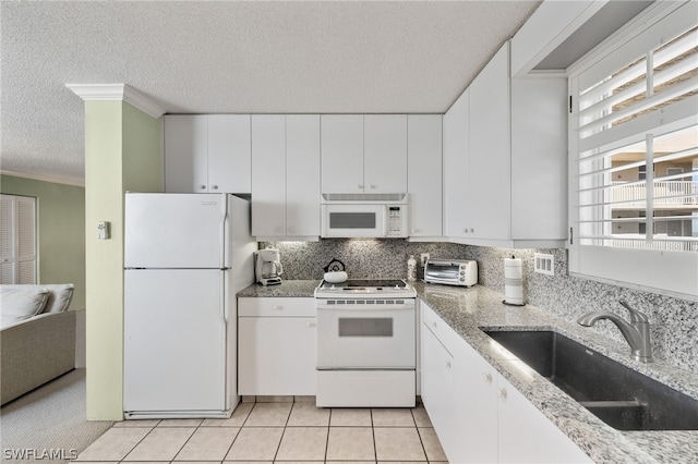 kitchen featuring white appliances, sink, backsplash, and white cabinetry