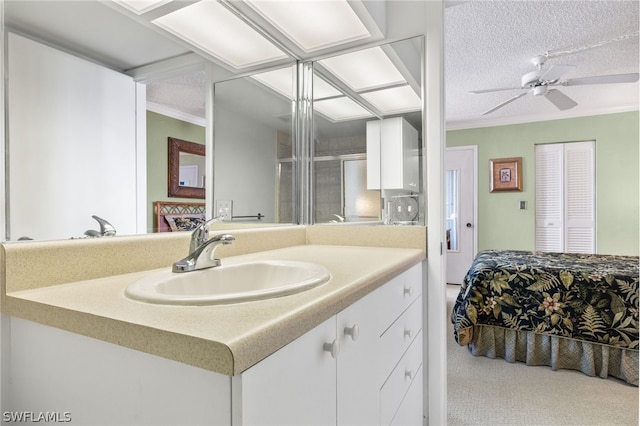 bathroom featuring a textured ceiling, ceiling fan, and vanity with extensive cabinet space