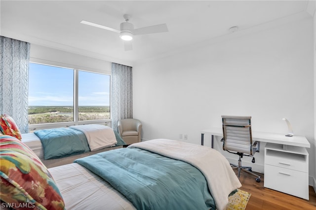 bedroom featuring wood-type flooring, ceiling fan, and crown molding