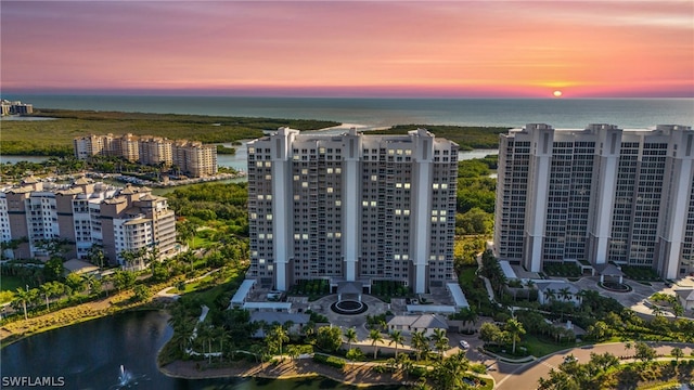 aerial view at dusk featuring a water view