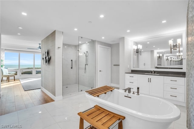 bathroom with a water view, separate shower and tub, vanity, and tile floors