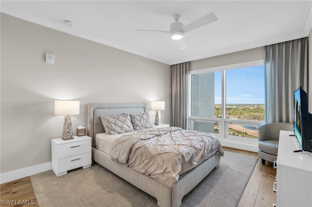 bedroom with crown molding, light wood-type flooring, and ceiling fan