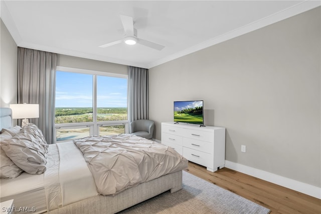 bedroom featuring ornamental molding, ceiling fan, and light hardwood / wood-style flooring