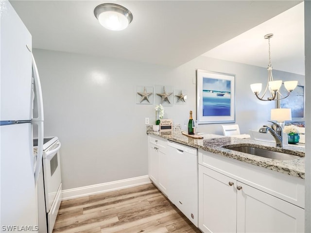 kitchen featuring an inviting chandelier, white cabinetry, white appliances, pendant lighting, and sink