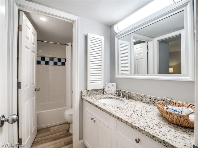 full bathroom with wood-type flooring, toilet, vanity, and shower / tub combo