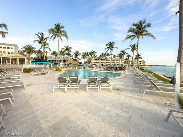 view of swimming pool with a water view and a patio