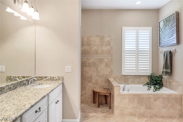 bathroom with tiled tub, vanity, and tile patterned floors