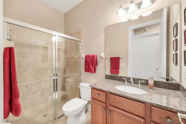 full bath with a stall shower, toilet, and vanity