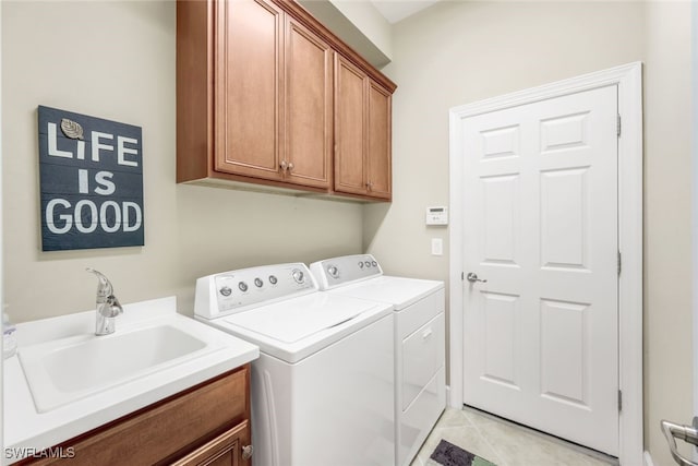 clothes washing area with washer and clothes dryer, cabinets, sink, and light tile patterned flooring