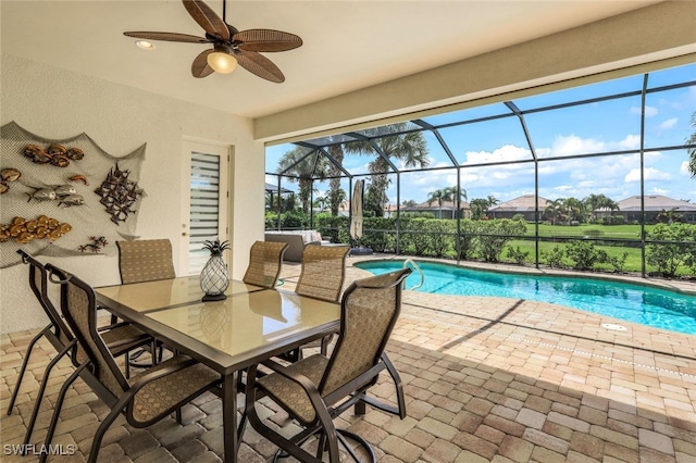 pool with ceiling fan, a lanai, a patio, and outdoor dining area