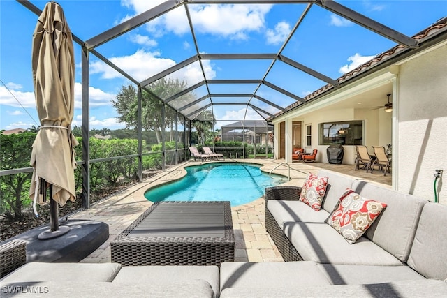 pool with glass enclosure, ceiling fan, an outdoor hangout area, and a patio area
