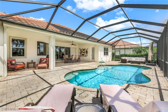 view of pool with glass enclosure, ceiling fan, and a patio area