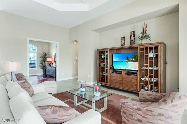 living room with baseboards, tile patterned flooring, and a skylight