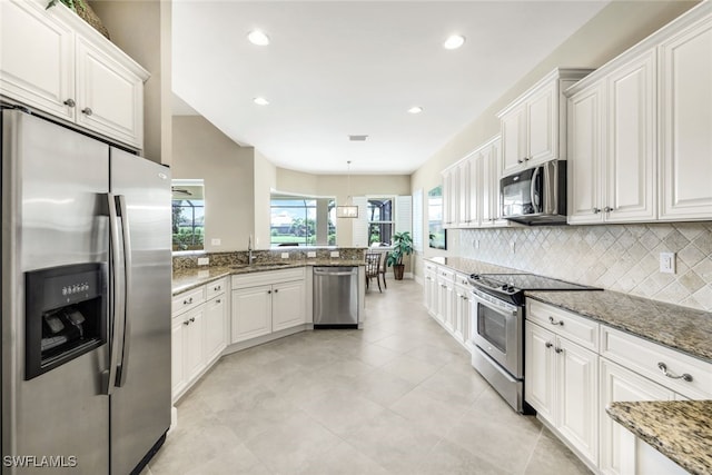 kitchen with a sink, white cabinetry, backsplash, and appliances with stainless steel finishes
