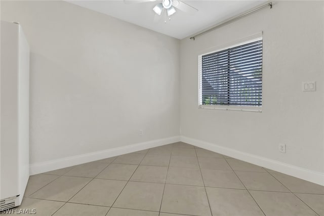 tiled spare room with ceiling fan