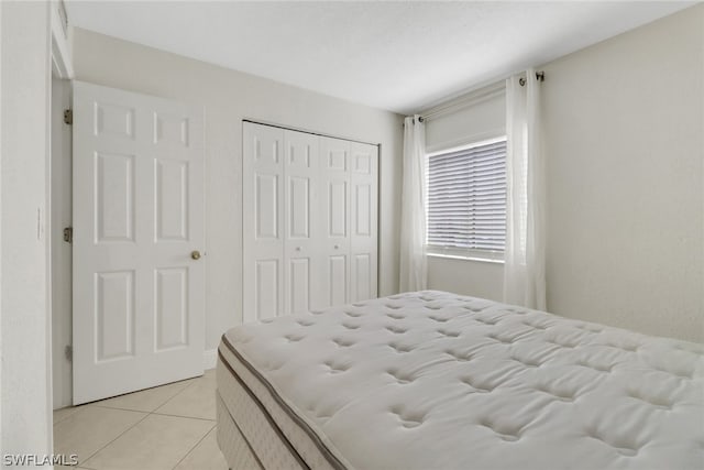 bedroom with a closet and light tile floors